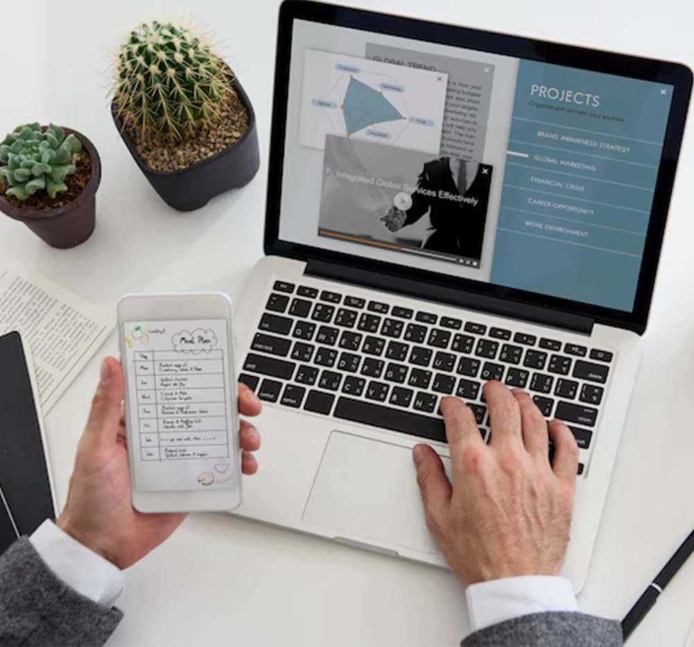 Man engaged with a laptop and mobile device, illustrating the process of creating a project for a web design company.