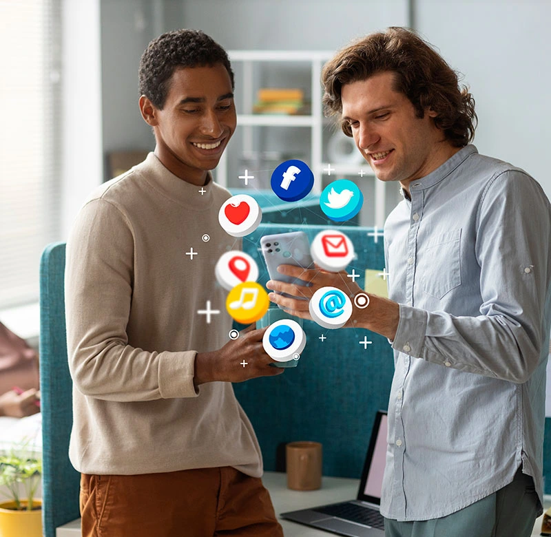 Two men examine a phone displaying social media icons, highlighting modern digital marketing strategies.